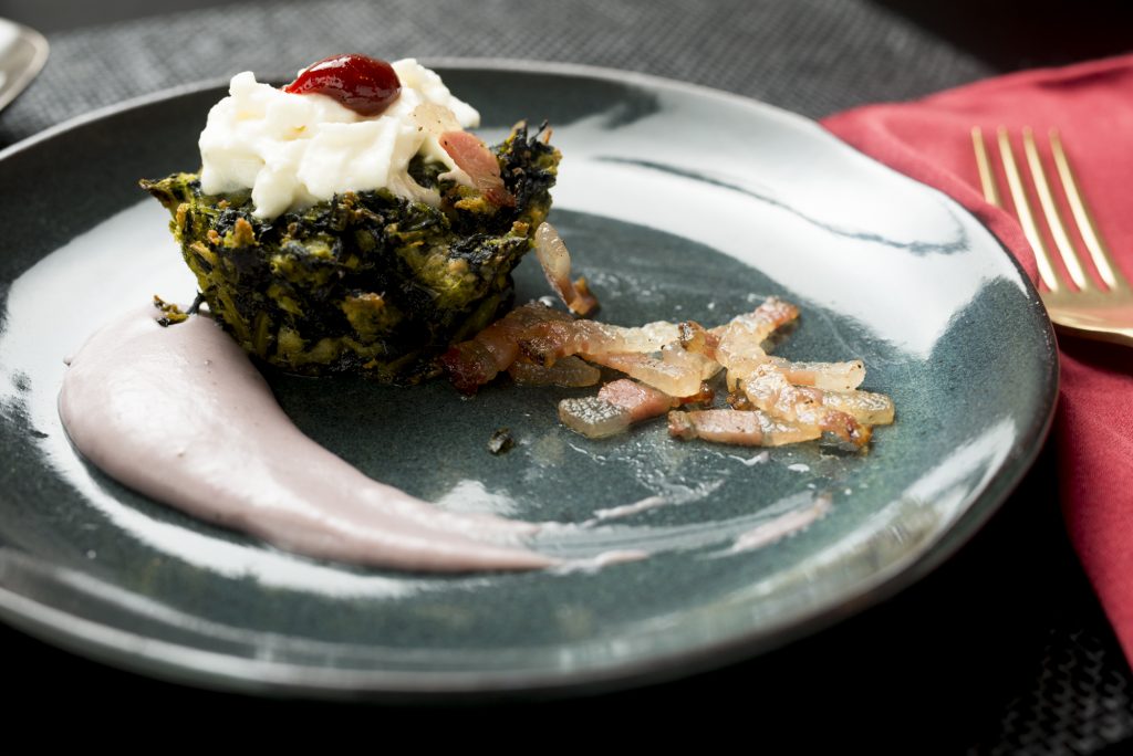 Tortino di pane e cavolo nero su crema di patate viola con guanciale croccante e bufala